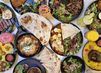 A vibrant spread of Middle Eastern dishes with fresh salads and drinks, captured in Vancouver.