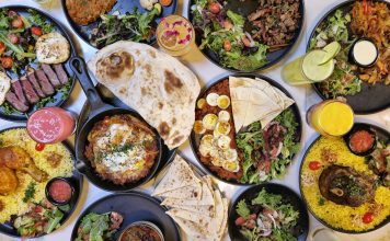 A vibrant spread of Middle Eastern dishes with fresh salads and drinks, captured in Vancouver.