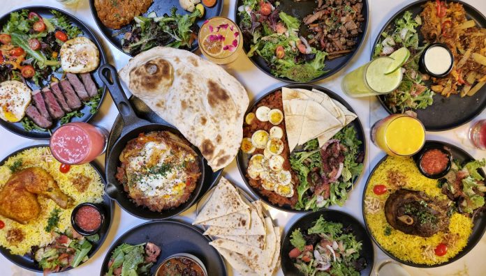 mejor-comida-halal-en-union-city-2026-guia-complet A vibrant spread of Middle Eastern dishes with fresh salads and drinks, captured in Vancouver.