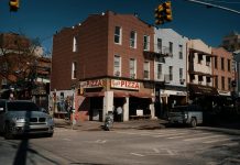 La Mejor Pizza en Bayonne en 2026: Guía Definitiva para los Amantes de la Pizza Street view of Joe's Pizza on a sunny day in Brooklyn, showcasing the lively urban atmosphere.