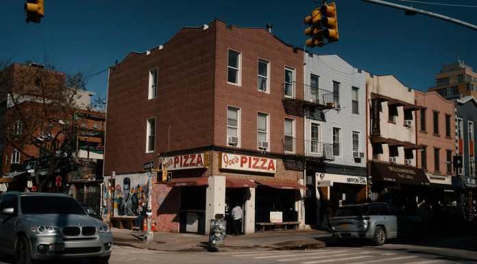 La Mejor Pizza en Bayonne en 2026: Guía Definitiva para los Amantes de la Pizza Street view of Joe's Pizza on a sunny day in Brooklyn, showcasing the lively urban atmosphere.