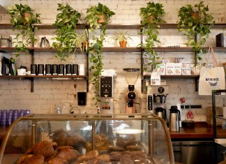 Los Mejores Cafés en North Bergen, NJ – Guía 2026 para Amantes del Café Inviting café in Montreal featuring a display of pastries and lush plants on shelves.