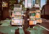 Colorful street food carts on a sunny New York City street offer a diverse culinary experience.