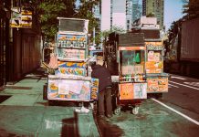 Colorful street food carts on a sunny New York City street offer a diverse culinary experience.