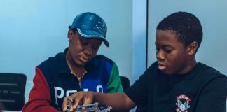 Two students assembling a robot in a hands-on STEM workshop in Accra, Ghana.