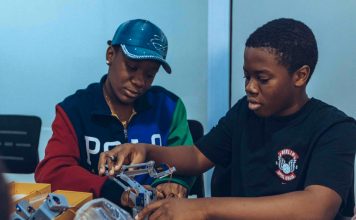 Two students assembling a robot in a hands-on STEM workshop in Accra, Ghana.