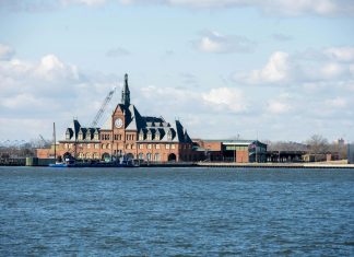 Pros and Cons of Living in Bayonne: A 2026 Local Guide Scenic view of the historic Ellis Island train station with clock tower set against a bright sky.