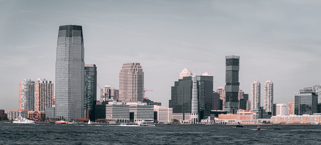 A breathtaking view of Jersey City's skyline from across the Hudson River with modern skyscrapers and waterfront buildings.