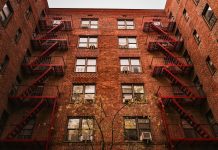 View of iconic red brick apartments with fire escapes in New York.