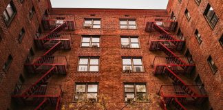 View of iconic red brick apartments with fire escapes in New York.
