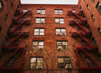 View of iconic red brick apartments with fire escapes in New York.