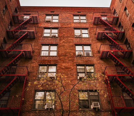 View of iconic red brick apartments with fire escapes in New York.