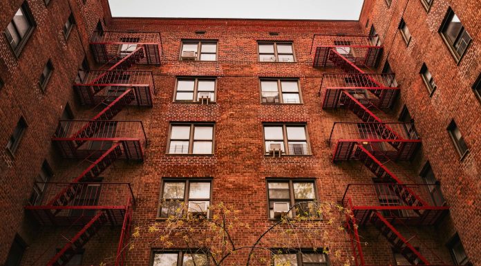 View of iconic red brick apartments with fire escapes in New York.
