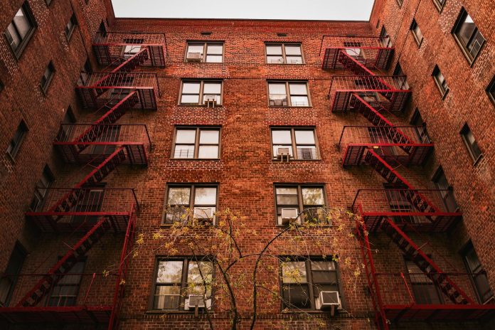 View of iconic red brick apartments with fire escapes in New York.