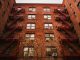 View of iconic red brick apartments with fire escapes in New York.