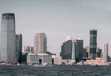 A breathtaking view of Jersey City's skyline from across the Hudson River with modern skyscrapers and waterfront buildings.