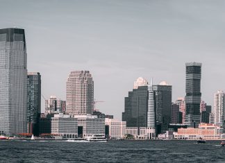 A breathtaking view of Jersey City's skyline from across the Hudson River with modern skyscrapers and waterfront buildings.