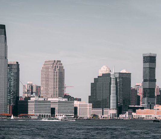 A breathtaking view of Jersey City's skyline from across the Hudson River with modern skyscrapers and waterfront buildings.