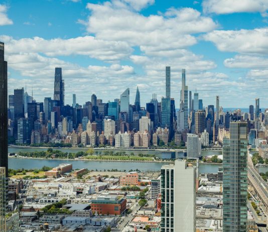 Explore the stunning New York City skyline with a clear view of iconic skyscrapers under a vibrant sky.