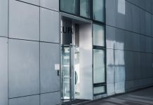 West New York retail center sells for $9.5M in first-ever trade Sleek modern architecture featuring a glass entrance with reflective facade, showcasing contemporary design.