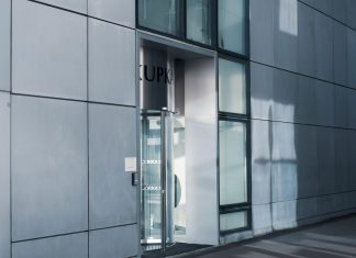 West New York retail center sells for $9.5M in first-ever trade Sleek modern architecture featuring a glass entrance with reflective facade, showcasing contemporary design.