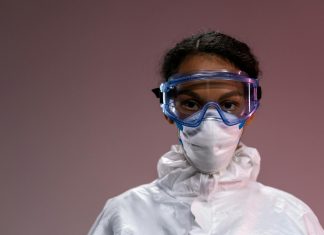 WHO Declares Ebola Outbreak a Global Emergency: What Hudson County Needs to Know Portrait of a healthcare worker wearing protective gear including goggles and mask.