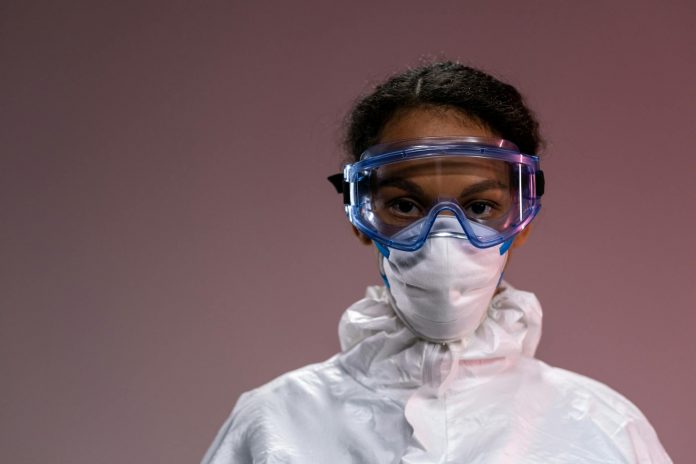 who-declares-ebola-outbreak-a-global-emergency-wha Portrait of a healthcare worker wearing protective gear including goggles and mask.