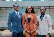 Three young professionals in stylish suits posing confidently outdoors.