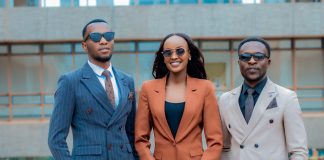 Three young professionals in stylish suits posing confidently outdoors.