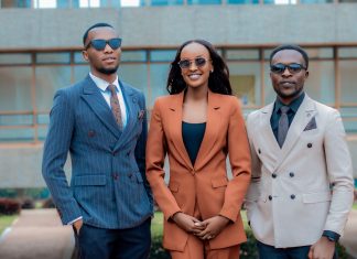 Three young professionals in stylish suits posing confidently outdoors.