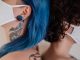 Bayonne police identify suspect in $60K jewelry store armed robbery Two women back to back wearing face masks, showcasing tattoos and colorful hair.