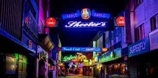 Explore the vibrant neon-lit streets of Hamburg's famous Reeperbahn district at night.