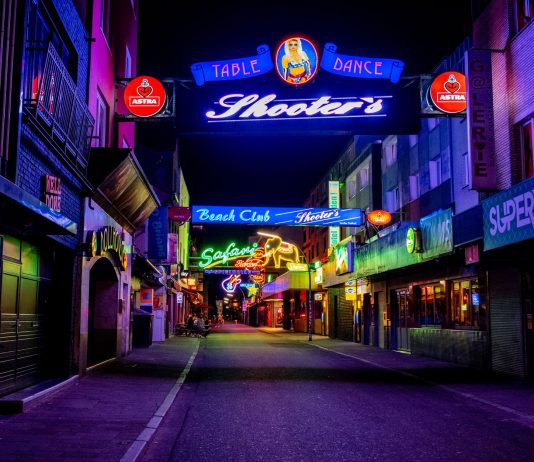Explore the vibrant neon-lit streets of Hamburg's famous Reeperbahn district at night.