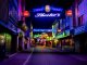 Explore the vibrant neon-lit streets of Hamburg's famous Reeperbahn district at night.
