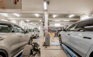 Interior of an automotive repair shop with cars undergoing maintenance and servicing.
