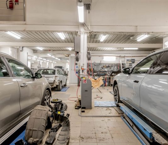 Interior of an automotive repair shop with cars undergoing maintenance and servicing.