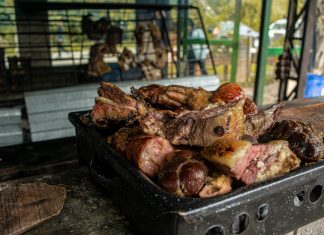 A close-up of a fresh, rustic barbecue platter filled with various grilled meats, perfect for outdoor gatherings.