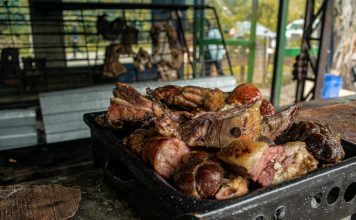 A close-up of a fresh, rustic barbecue platter filled with various grilled meats, perfect for outdoor gatherings.