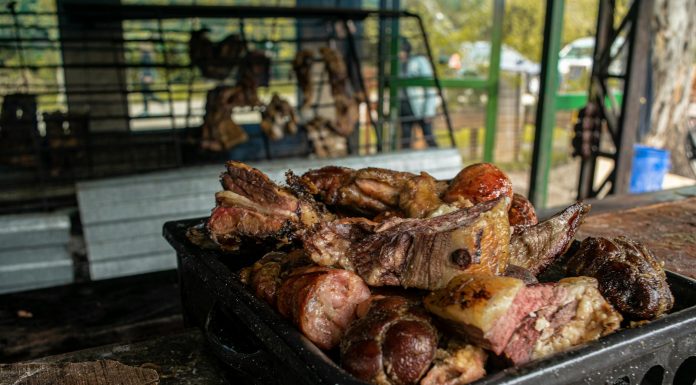 A close-up of a fresh, rustic barbecue platter filled with various grilled meats, perfect for outdoor gatherings.