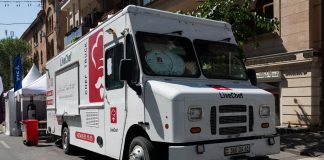 White food truck by LiveChef at a bustling street festival under sunny skies.