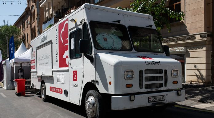 White food truck by LiveChef at a bustling street festival under sunny skies.