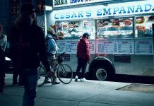 Vibrant urban scene of people enjoying a food truck at night in New York City.