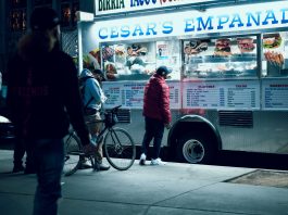 Vibrant urban scene of people enjoying a food truck at night in New York City.