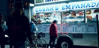 Vibrant urban scene of people enjoying a food truck at night in New York City.