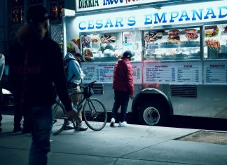 Vibrant urban scene of people enjoying a food truck at night in New York City.