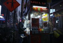 Urban street food vendor serving at night in New York City, capturing the bustling nightlife.
