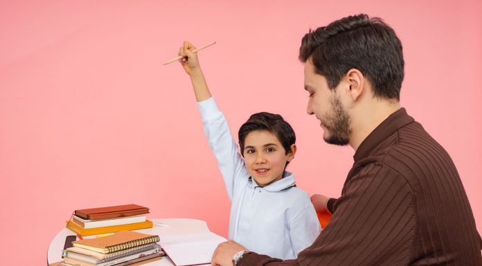 Teacher aids enthusiastic student in classroom setting, enhancing learning experience.