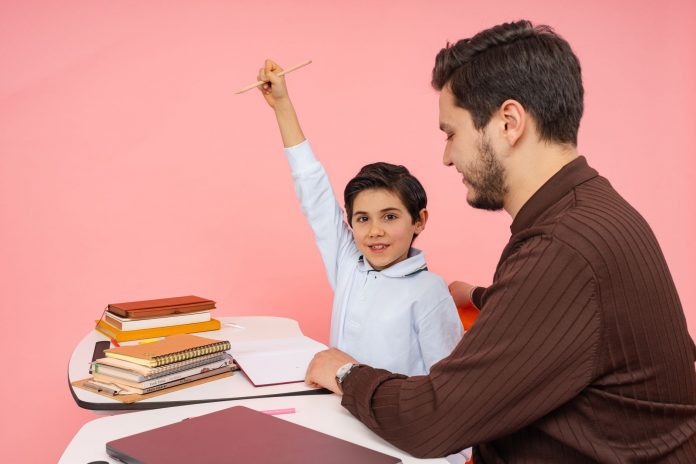 best-private-schools-near-bayonne Teacher aids enthusiastic student in classroom setting, enhancing learning experience.