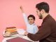Teacher aids enthusiastic student in classroom setting, enhancing learning experience.