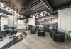 Comfortable backwash chairs with sinks near potted plant placed in contemporary beauty salon with bright illumination and abundance of cosmetology products